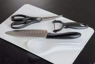 a pair of scissors sitting on a white cutting board at Funabori in Tokyo
