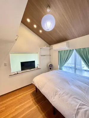 a bedroom with a bed and a flat screen tv at fukuhana \u6771\u65b0\u5bbf C8 in Tokyo
