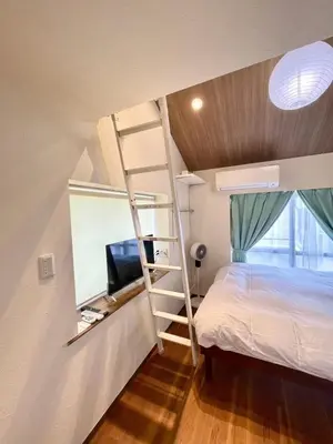 a bedroom with a bunk bed and a television at fukuhana \u6771\u65b0\u5bbf C8 in Tokyo