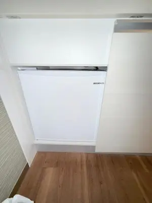 a white refrigerator in a room with a wooden floor at fukuhana \u6771\u65b0\u5bbf C8 in Tokyo
