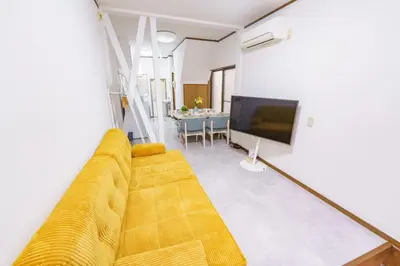 a living room with a yellow couch and a television at Konoha Sangenjaya DZ4 in Tokyo