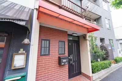 a brick building with a black door on a street at Konoha Sangenjaya DZ4 in Tokyo