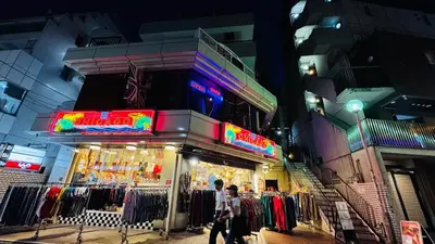 a man walking past a clothing store at night at Konoha Sangenjaya DZ4 in Tokyo