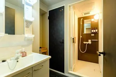 a bathroom with a shower and a sink and a toilet at Living Stay Plum Residence - Authentic Tokyo Stay - Direct to HND 20m & Shinagawa in Tokyo