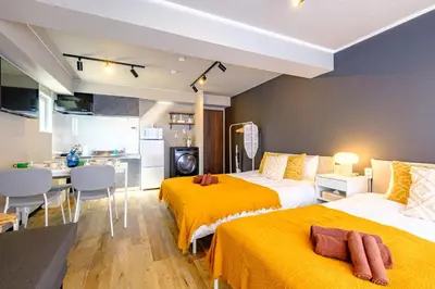 a hotel room with two beds and a kitchen at Living Stay Plum Residence - Authentic Tokyo Stay - Direct to HND 20m & Shinagawa in Tokyo