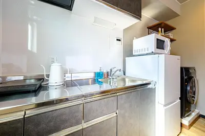a kitchen with a sink and a microwave at Living Stay Plum Residence - Authentic Tokyo Stay - Direct to HND 20m & Shinagawa in Tokyo