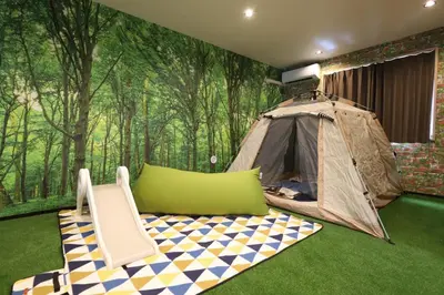 a tent and a chair in a room with a forest mural at \u30e9\u30dd\u30fc\u30eb\u6771\u5411\u5cf6 in Tokyo