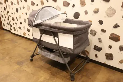a baby stroller in front of a wall with rocks at \u30e9\u30dd\u30fc\u30eb\u6771\u5411\u5cf6 in Tokyo