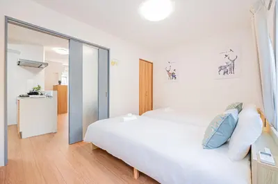 a bedroom with a large white bed with blue pillows at Mori house \u65b0\u5c0f\u5ca9B in Tokyo