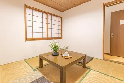 a room with a table with a vase of flowers on it at 3 Story Private House, 7 Min Walk to Yamanote Line Direct to Shinjuku, Ikebukuro, Shibuya in Tokyo