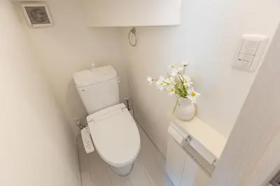 a bathroom with a toilet with a vase of flowers at 3 Story Private House, 7 Min Walk to Yamanote Line Direct to Shinjuku, Ikebukuro, Shibuya in Tokyo
