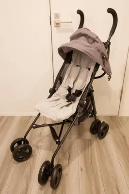 a baby stroller sitting on a wooden floor at TOMALCO INN NAKANO 2 3F Flat 2 Bath 13 min to Shinjuku from Honancho in Tokyo