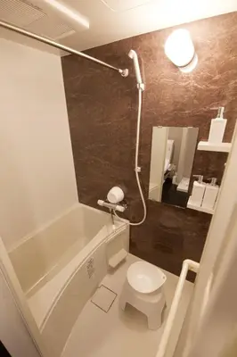 a bathroom with a white toilet and a bath tub at TOMALCO INN NAKANO 2 3F Flat 2 Bath 13 min to Shinjuku from Honancho in Tokyo