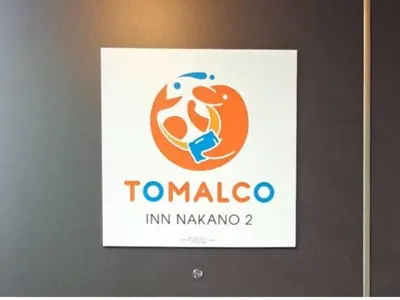 a sign on a wall with the logo of tomango at TOMALCO INN NAKANO 2 3F Flat 2 Bath 13 min to Shinjuku from Honancho in Tokyo