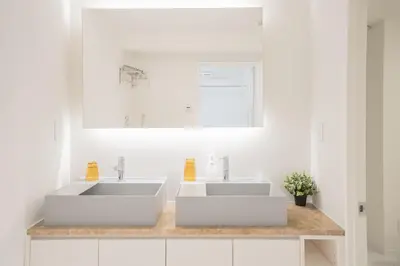 a white bathroom with two sinks and a mirror at Brand New Luxury Suite 7 min to Omotesando 2 min to Shibuya in Tokyo