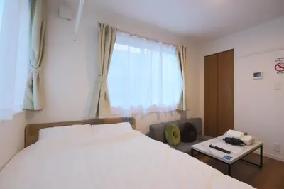 a bedroom with a white bed and a window at \u30af\u30ea\u30aa-\u30e9\u30e2\u30fc\u30c9\u5927\u68ee in Tokyo