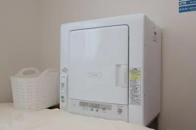 a white microwave oven sitting on top of a bed at \u30af\u30ea\u30aa-\u30e9\u30e2\u30fc\u30c9\u5927\u68ee in Tokyo