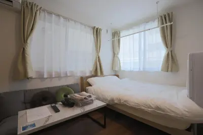 a small bedroom with a bed and a window at \u30af\u30ea\u30aa-\u30e9\u30e2\u30fc\u30c9\u5927\u68ee in Tokyo
