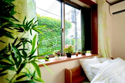 a bedroom with a window with potted plants on a window sill at Shinjuku Y HOTEL II 1 minute to 7-Eleven 6DK 2 bathrooms in Tokyo