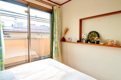 a bedroom with a window and a bed and a clock at Shinjuku Y HOTEL II 1 minute to 7-Eleven 6DK 2 bathrooms in Tokyo