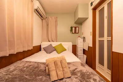 a small bedroom with a bed with towels on it at iroha in Tokyo