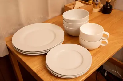 three white plates and cups on a wooden table at iroha in Tokyo