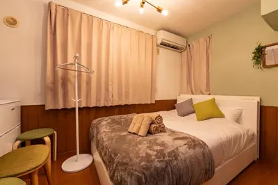a bedroom with a bed and a table and chairs at iroha in Tokyo