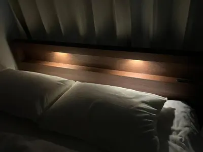 a bed with a headboard with lights on it at \u7acb\u5730\u6700\u9ad8 \u65b0\u5bbf\u6b4c\u821e\u4f0e\u753a \u65b0\u5bbf\u99c5\u5f92\u6b69\u570f\u5185 \u6700\u59273\u540d\u69d8\u307e\u3067\u5bbf\u6cca\u53ef\u80fd 6\u8def\u7dda\u5229\u7528\u53ef\u80fd 6\u6b73\u4ee5\u4e0b\u306f\u7121\u6599\u3067\u3059 in Tokyo
