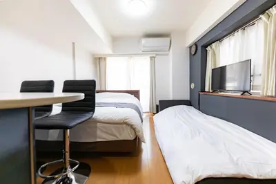 a bedroom with a bed and a desk and a tv at \u7acb\u5730\u6700\u9ad8 \u65b0\u5bbf\u6b4c\u821e\u4f0e\u753a \u65b0\u5bbf\u99c5\u5f92\u6b69\u570f\u5185 \u6700\u59273\u540d\u69d8\u307e\u3067\u5bbf\u6cca\u53ef\u80fd 6\u8def\u7dda\u5229\u7528\u53ef\u80fd 6\u6b73\u4ee5\u4e0b\u306f\u7121\u6599\u3067\u3059 in Tokyo