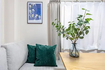 a vase with a plant on a table in a living room at \u65b0\u5bbfClassy House in Tokyo