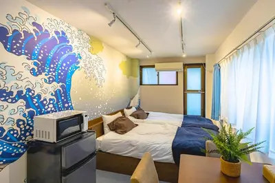 a bedroom with a blue and white wave mural on the wall at \u65b0\u5bbfClassy House in Tokyo