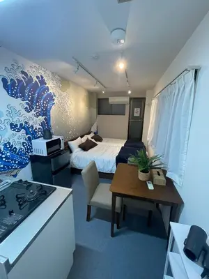 a room with a bed and a table and a kitchen at \u65b0\u5bbfClassy House in Tokyo