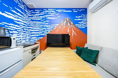 a kitchen with a table with a mountain mural on the wall at \u65b0\u5bbfClassy House in Tokyo