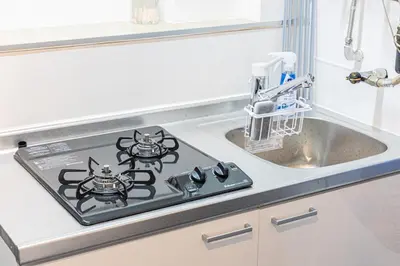 a stove top in a kitchen next to a sink at \u65b0\u5bbfClassy House in Tokyo