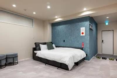 a bedroom with a bed and a blue wall at Sharil Shiina-machi in Tokyo