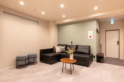 a living room with a black couch and a table at Sharil Shiina-machi in Tokyo