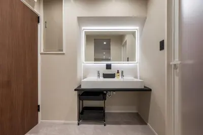 a bathroom with a white sink and a mirror at Sharil Shiina-machi in Tokyo