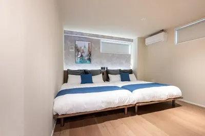 a bedroom with a large bed with blue pillows at Sharil Shiina-machi in Tokyo