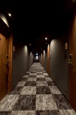 a long hallway with a tile floor in a building at Hotel Matsunoi Shurin in Tokyo