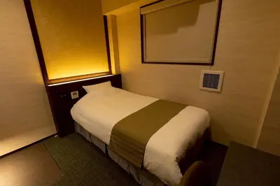 a hotel room with a bed and a mirror at Hotel Matsunoi Shurin in Tokyo