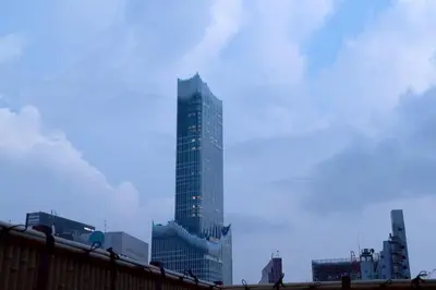 a tall glass skyscraper in a city at Hotel Matsunoi Shurin in Tokyo