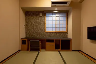 a room with a table and a chair and a window at Hotel Matsunoi Shurin in Tokyo