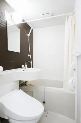 a white bathroom with a sink and a toilet at Tokyo Ueno Mia Hotel in Tokyo