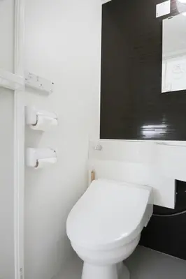 a white toilet in a bathroom with a black wall at Tokyo Ueno Mia Hotel in Tokyo