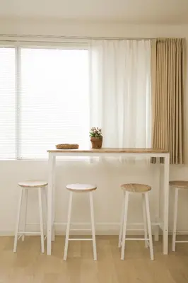 a white table with three stools in front of a window at Tokyo Ueno Mia Hotel in Tokyo