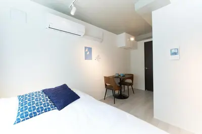 a bedroom with a white bed and a table at Bellie Sangenjaya by Tranova in Tokyo