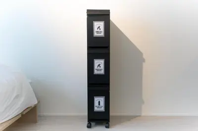a black shelf with three pictures on it next to a bed at Bellie Sangenjaya by Tranova in Tokyo