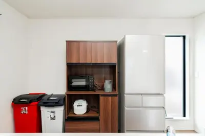 a kitchen with a refrigerator and a trash can at \u5c0f\u6797 home in Tokyo