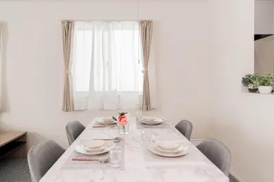 a dining room table with chairs and a white table cloth at \u5c0f\u6797 home in Tokyo