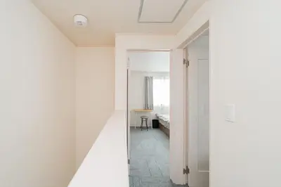 a room with a hallway with a bed and a mirror at \u5c0f\u6797 home in Tokyo